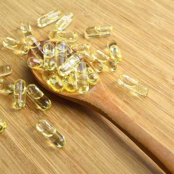 Sarı Balık Yağı Oval Tablet Haplar Ahşap Kaşık Bambu Kesme — Stok fotoğraf