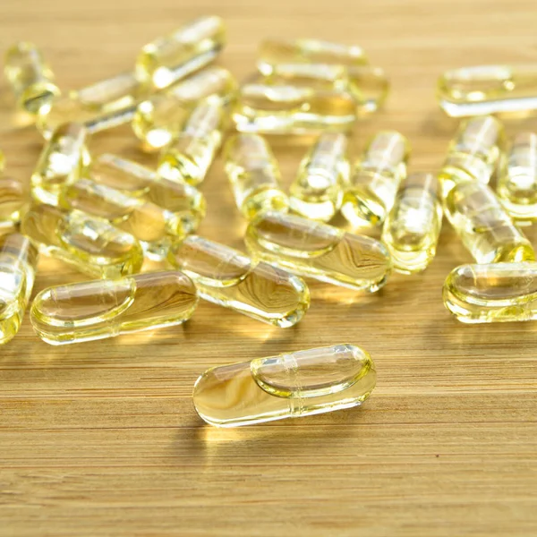 Gelbes Fischöl Ovale Tabletten Tabletten Auf Bambus Schneidebrett Medizinische Ovale — Stockfoto