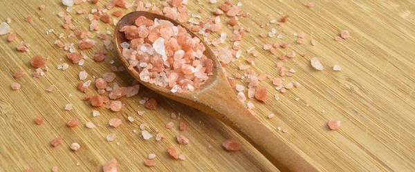 木制背景的木制勺子中健康的粉红色海玛拉盐 — 图库照片