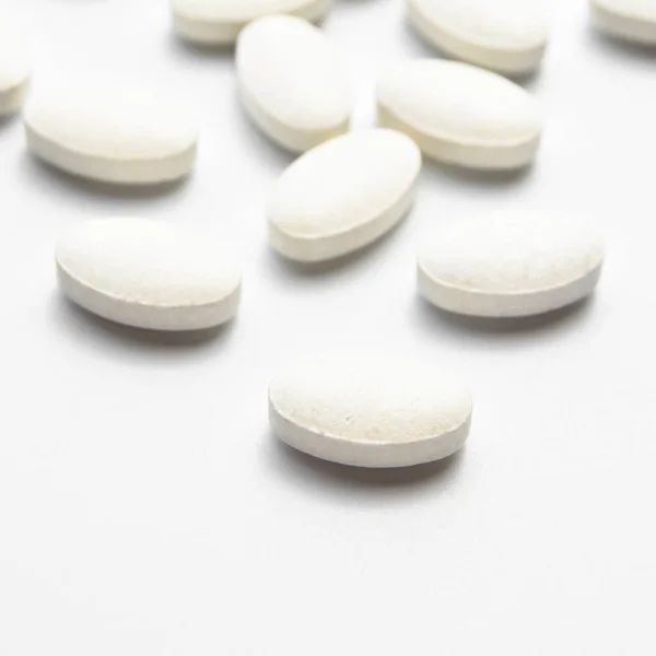 Białe Owalne Tabletki Wyizolowane Białym Tle Owalne Tabletki Medyczne — Zdjęcie stockowe