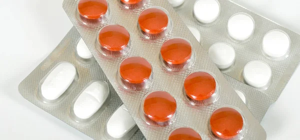 白い背景に隔離された健康的な環境でパックされ 使用される白とオレンジの錠剤 — ストック写真