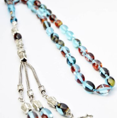 Renkli ve gümüş boncuklar sıralı, kısa tespih tesbih, Türk kültürü için önemli bir aksesuar, beyaz arka planda izole edilmiş.