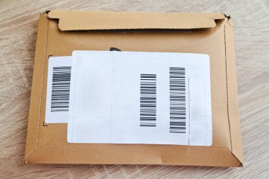 Kahverengi ve bej renkli karton zarflar yapışkan barkodların üzerinde. Şirket yazışmalarında kullanılabilir.