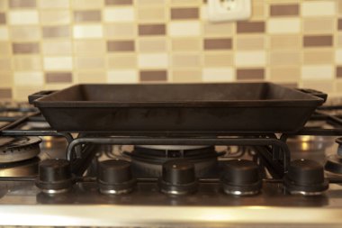 Boş siyah döküm, modern bir mutfakta gaz ocağında ağır demir ızgara tavası.