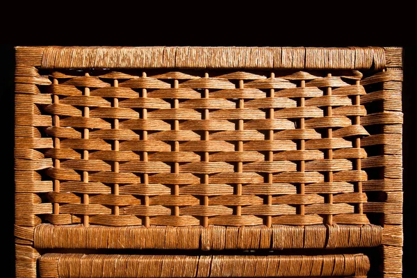 Rattan wicker brown basket with handmade traditional and dry branches, natural pattern woven wicker basket, isolated on black background