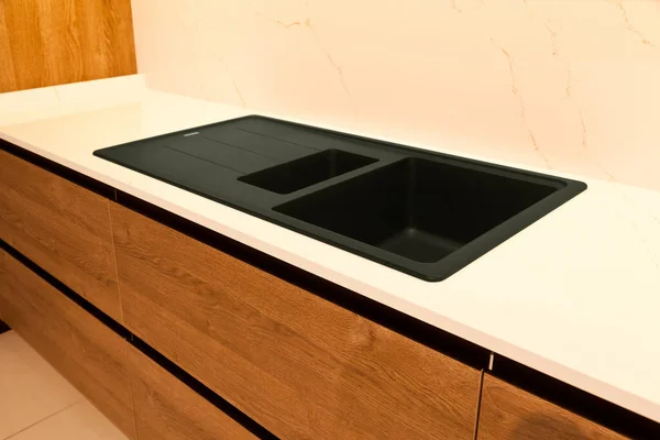 现代褐木橡木厨房设备和时尚花岗岩黑色洗涤槽在家里 — 图库照片