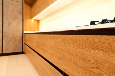 Modern kahverengi meşe mutfak malzemeleri, şık beyaz granit tezgah ve bir evde cam gaz sobası.