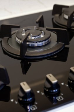 Modern temiz mutfak ve siyah cam seramik gazlı fırın düğmesi detayı