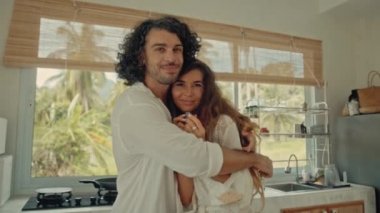 Genç, mutlu, evli çift dans ediyor. Birlikte gülüyorlar. Evde yemek pişiriyorlar. Kaygısız, neşeli karı koca, Boho tarzı mutfakta sağlıklı kahvaltı hazırlıyorlar.