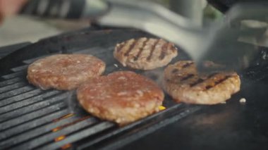 Izgarada Hazır Etli Patty. Aşçı taze kıymadan Burger için bir Patty çeşniliyor.