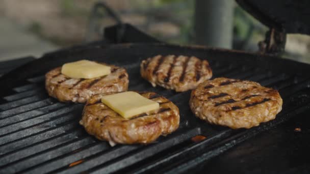 Ein Fleisch-Patty, das auf dem Grill zubereitet wird. Koch würzt Patty für Burger aus frischem Hackfleisch — Stockvideo