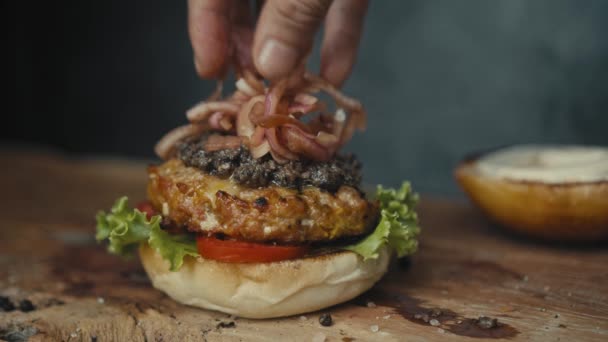 Chef a preparar o hambúrguer. Close up - mão de homem esfrega molho hambúrguer frito para um hambúrguer. Movimento lento — Vídeo de Stock