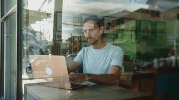 Digital Nomad works on a laptop in a coffee shop — Vídeo de Stock