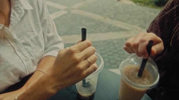 Two women sit in a coffee shop on the street and discuss — Stock video