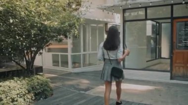 Güzel genç bir kadın sabah iş yerinde elinde dizüstü bilgisayarla yürüyor. Çekici esmer kız öğrenci ya da yaratıcı kadın serbest yazar, konsept. 4k ağır çekim