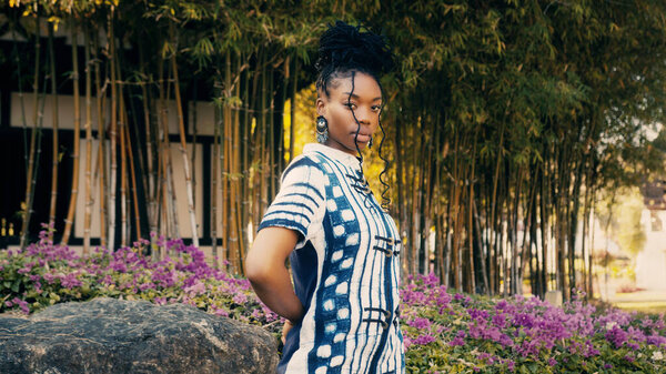 Fashion portrait of a beautiful African-American woman by a Chinese architecture in the background. ethno concept