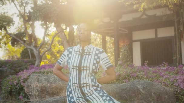 Mujer afroamericana con estilo en ropa de moda de pie frente a un edificio chino — Vídeos de Stock