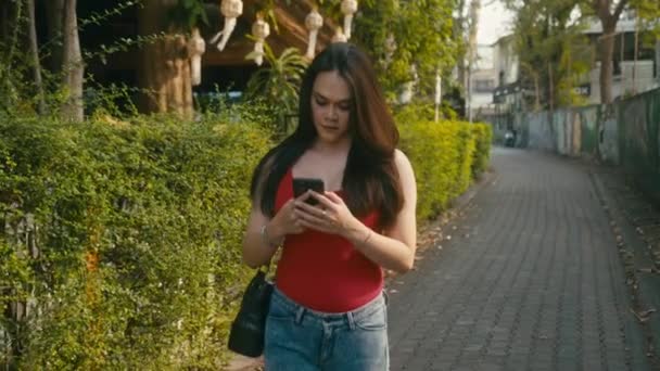Een mooie trans vrouw chatten tijdens het lopen door de straat — Stockvideo
