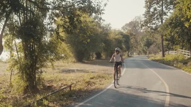 Radfahrermädchen beim Training. Radfahrerin mit Helm auf Fahrrad — Stockvideo