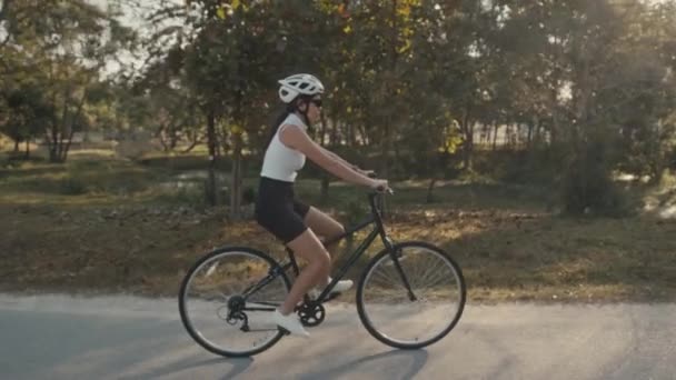 Ciclista chica de entrenamiento. Mujer ciclista en casco en bicicleta — Vídeo de stock