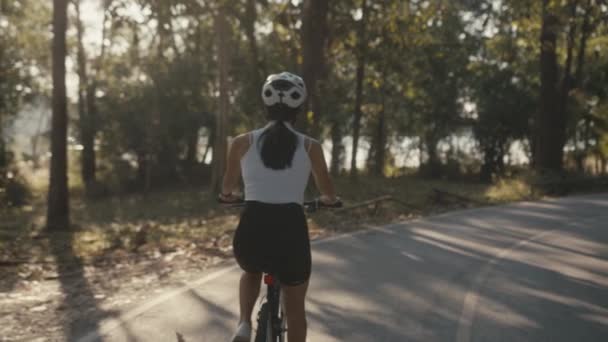Wielrenner meisjestraining. Fietsvrouw in helm op de fiets — Stockvideo
