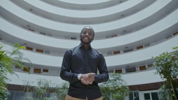 Fiatal afro-amerikai üzletember áll a vállalati épület előtt — Stock videók