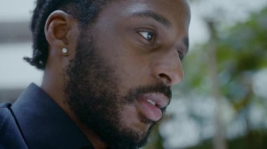 Genç Afro-Amerikalı iş adamı sokakta dizüstü bilgisayarla çalışıyor. 