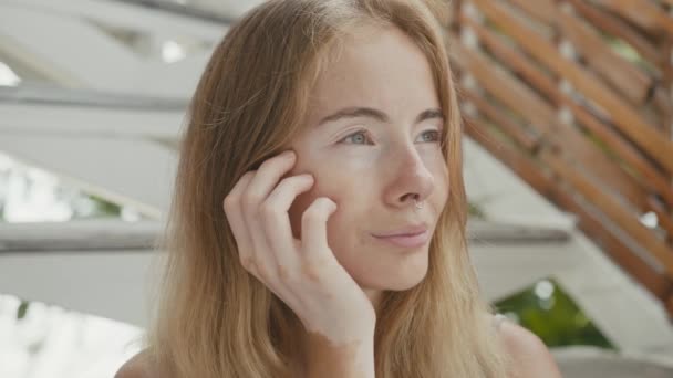Hezká mladá žena s vitiligovým pigmentem sedí na schodech, dívá se do kamery — Stock video
