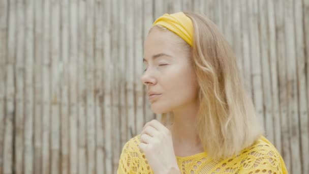 Módní portrét roztomilé mladé ženy s vitiligo pigmentací pózující přes bambusovou stěnu, hledající na kameru — Stock video