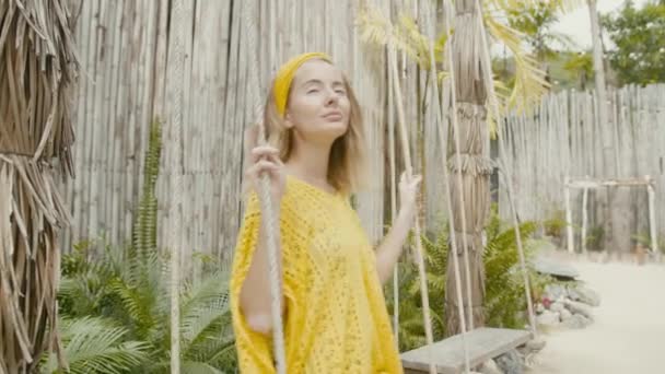 Fashion portrait of cute young woman with vitiligo pigmentation swinging on a swing and looking to camera — Video Stock