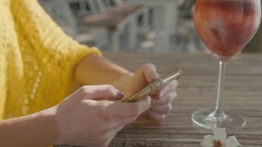 Vitiligo pigmentasyonu olan genç ve güzel bir kadın sahilde oturur, telefonda sohbet eder, ağır çekimde.