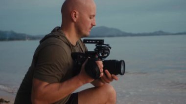 Kameralı bir kameraman güzel bir gün batımı çekiyor.