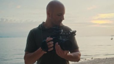 Kameralı bir kameraman güzel bir gün batımı çekiyor.