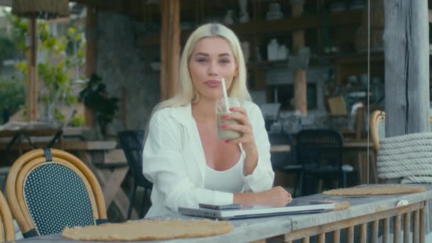 Blonda Cămașă Albă Lucrează Laptop Cafenea Uitându Cameră Bea Shake — Videoclip de stoc