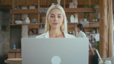 Güzel Ukraynalı sarışın kız dizüstü bilgisayar açıyor. Güzel sarışın kadın defter bilgisayarı üzerinde çalışmaya başlıyor. Kafe 'de çalışan serbest çalışan biri.