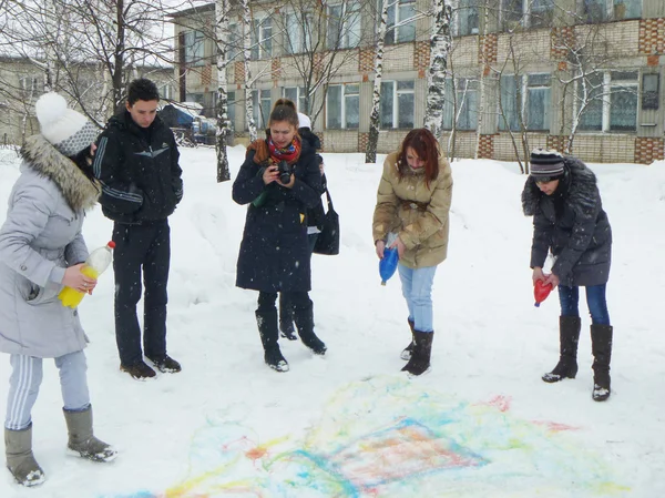 Girls draw paint on snow during holiday of the Shrovetide — Stock Photo, Image