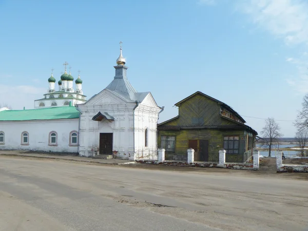 Старое деревянное здание рядом с часовней — стоковое фото