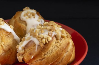 Masanın üzerinde kırmızı bir tabakta yuvarlak ekinoz var. Siyah arkaplanda yemek