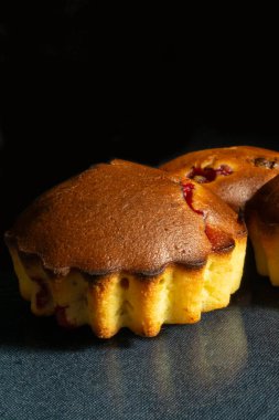 Tatlı meyveli kekler cam masada dinlenmek için böğürtlenli. Siyah arka planda ev yapımı.