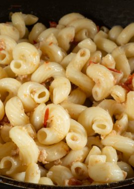 Tavada baharatlı kavrulmuş şehriye. Siyah arka planda lezzetli bir akşam yemeği.