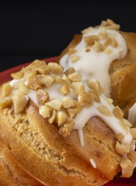 Masanın üzerinde kırmızı bir tabakta yuvarlak ekinoz var. Siyah arkaplanda yemek