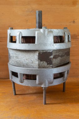 Tahta bir masanın üzerinde eski bir elektrikli motor. Endüstriyel nesne yakın plan.