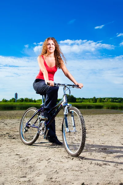 Schöne Frau mit Fahrrad am Meer — Stockfoto