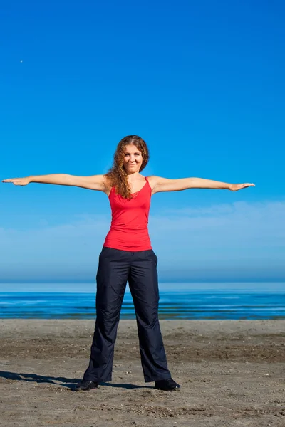 Menina fazendo exercícios matinais na praia — Fotografia de Stock