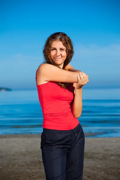 Chica haciendo ejercicios matutinos en la playa —  Fotos de Stock