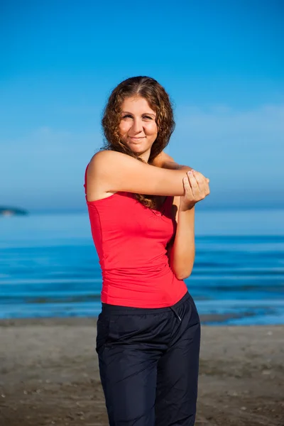 Ragazza che fa esercizi mattutini in spiaggia — Foto Stock