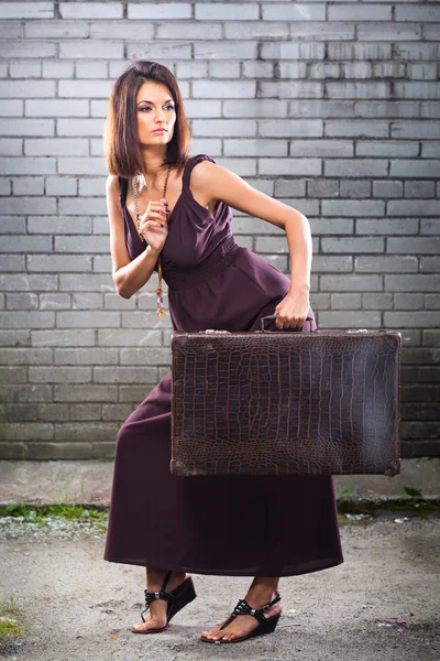 Hermosa chica ladrona con maleta vintage esperando en la estación —  Fotos de Stock