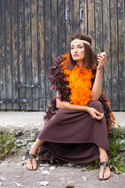 Herečka kouření v hnědé a oranžové boa — Stock fotografie