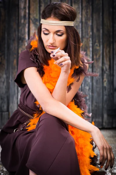 Smoking actress in brown and orange boa — Stock Photo, Image