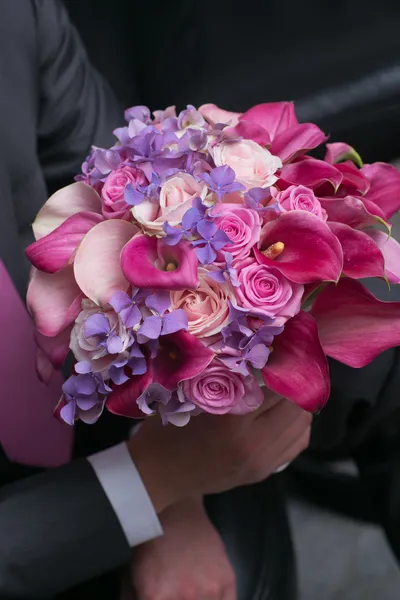 Wedding bouquet voor bruid in handen van de bruidegom — Stockfoto